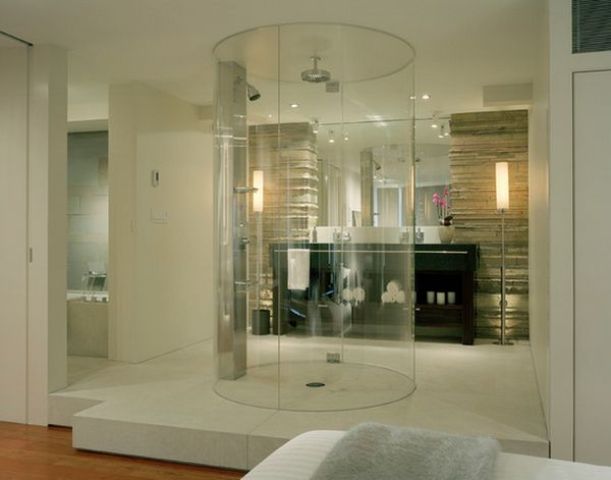 a neutral contemporary bedroom with a bathroom integrated here, with a clear glass round shower is a lovely idea