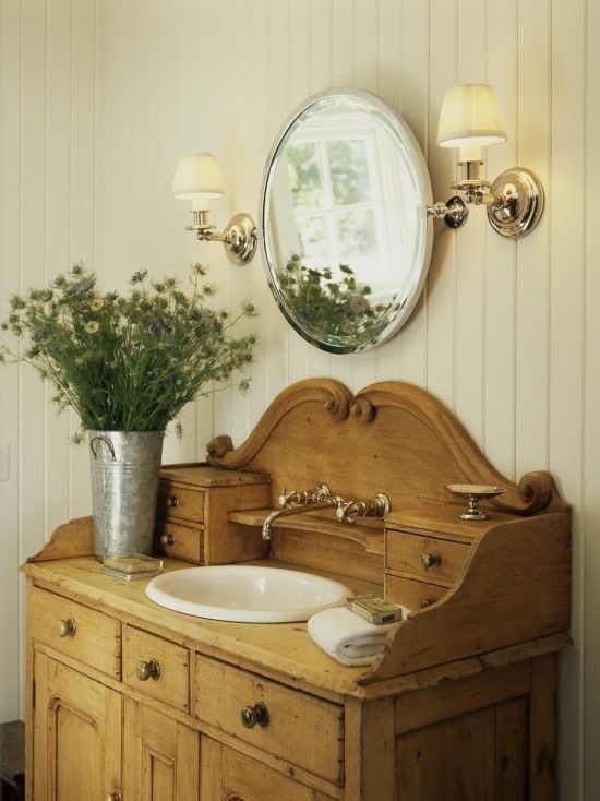 a vintage stained wooden cabinet with lots of tiny drawers used as a vanity for a country bathroom is a very cool and fresh idea