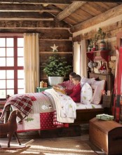 a rustic kids’ room decorated for Christmas with bright bedding and blankets, a Christmas tree with a star topper and some branches over the bed