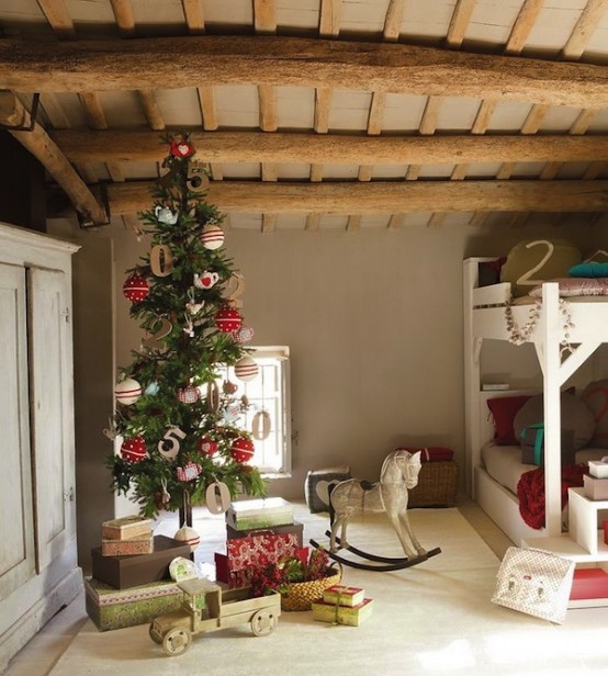 a Christmas tree with amazing red and white ornaments and gold letters plus printed and bold gift boxes stacked under the tree