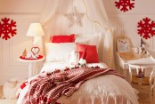 a beautiful neutral kid’s room with chic red Christmas decor – red pillows, red snowflakes, blankets and mini nightstands plus a star on the bed is very cozy