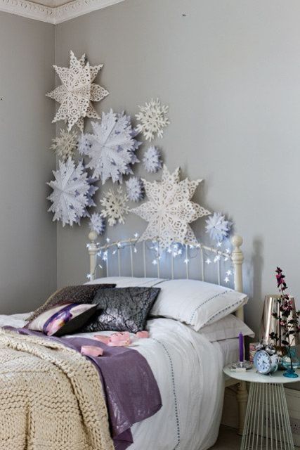 beautiful laser cut powder blue and white stars on the wall and some lights on the bed make the space look dreamy and very cute