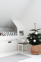 a Christmas tree wrapped in kraft paper and with monochromatic ornaments is ideal for a Nordic kids’ room