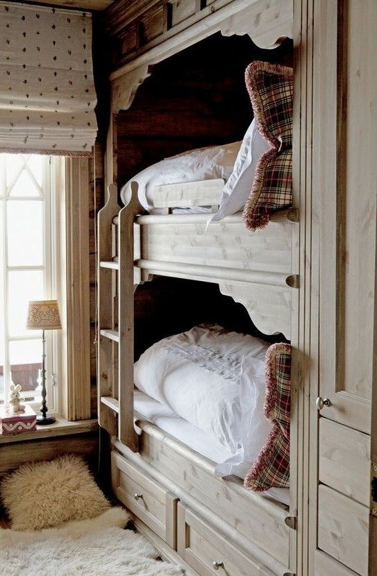 a vintage rustic bedroom with built-in bunk beds for kids, with a ladder and neutral bedding, a table lamp and faux fur rugs is a lovely and welcoming space