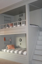 a grey kids’ room with built-in bunk beds with printed bedding and a ladder is a stylish and cozy space to be in