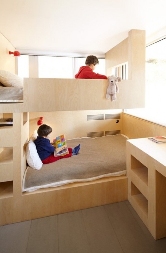 a minimalist kids' room with sleek plywood bunk beds built-in, a ladder and a desk with open storage is a cool space filled with natural light