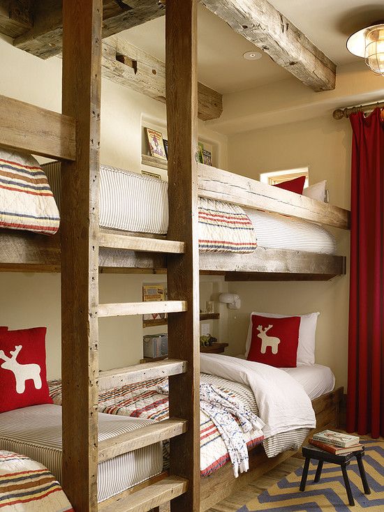 a welcoming kids' room with stained built in bunk beds, with a ladder and bright and neutral bedding, a rug and curtains