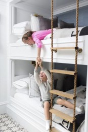 a modern kids’ room with a grey accent wall, a built-in bunk bed with neutral bedding and a rope ladder is a lovely idea to rock