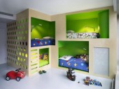 a bright kids’ room with built-in box bunk beds with green inside, built-in ladders and built-in sconces