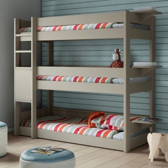 an ocean-inspired kids' room with a grey bunk bed, colorful bedding, an aqua accent wall and a pouf