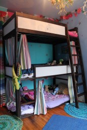 a colorful kids’ room with a bunk bed for three, colorful bedding, rugs and curtains and a ladder for easy getting to the top