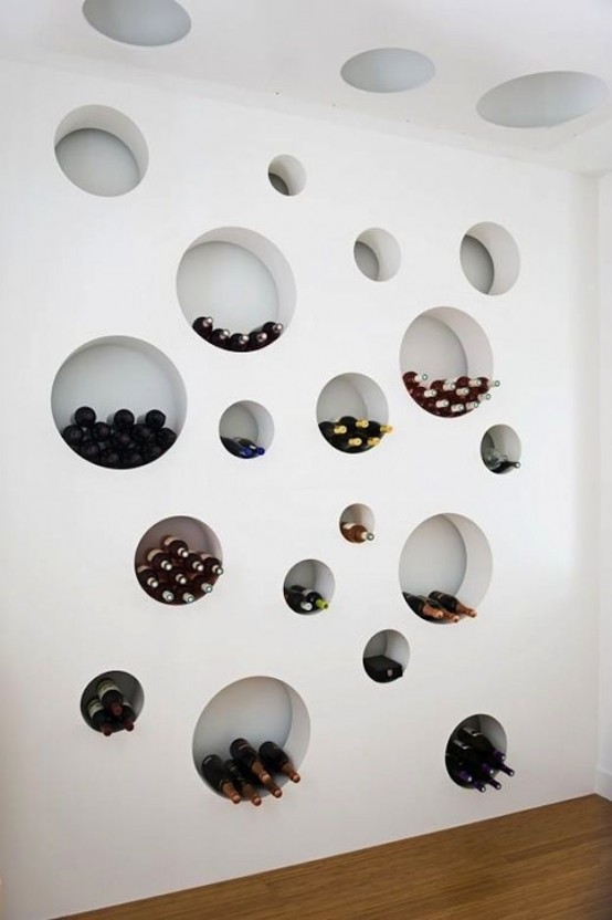 a wall with round cavities that are used to store wine bottles and other stuff is an artwork itself