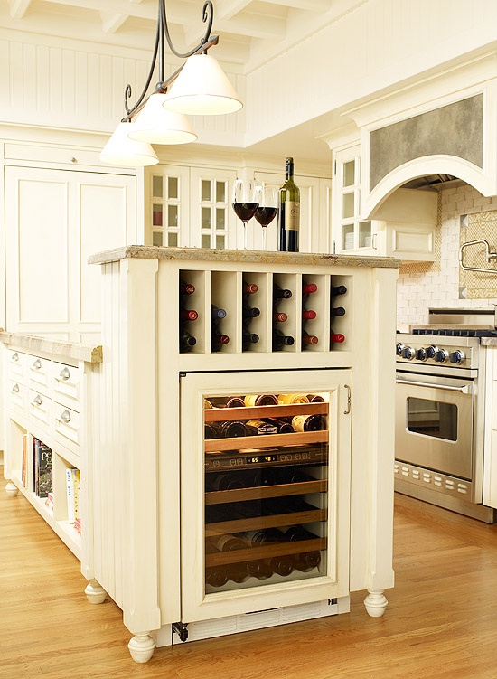 a large wine storage unit built into the kitchen island - a wine cooler and simple shelves for bottles