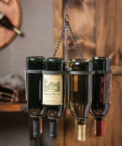 a metal hanger that holds bottles is a non-traditional and bold solution that doesn’t take floor space
