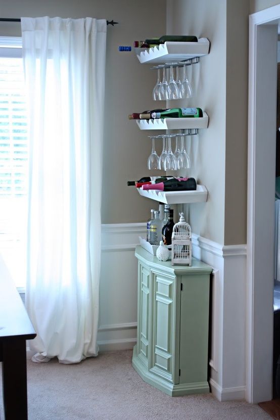 whiet contemporary shelves that hold bottles and additional wire glass holders