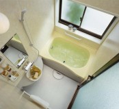 a tiny bathroom with a built-in bathtub, a tiny floating vanity with a built-in sink and a mirror