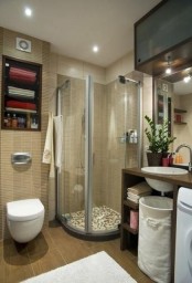 a modern small bathroom in sandy shades, built-in storage space, an open vanity and a shower