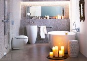 a modern relaxing bathroom with a stone floor, elegant appliances with curved looks, a shelf and a mirror over it