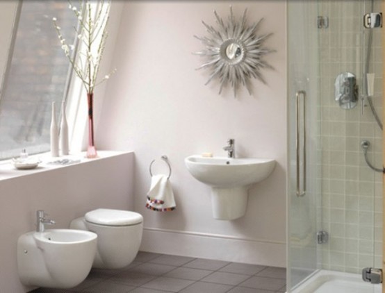 a pastel attic bathroom with floating appliances, a green tile shower space, a quirky sunburst mirror