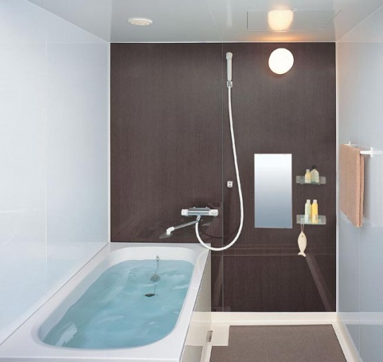 a tiny modern bathroom with a chocolate colored statement wall and a comfortable bathtub