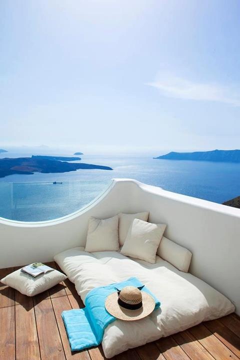 a minimalist seaside deck with a mattress, some pillows and a gorgeous sea view is a lovely space to be