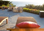 a seaside terrace with a sea view, a couple of loungers, rocks and candle lanterns is a gorgeous place to spend time