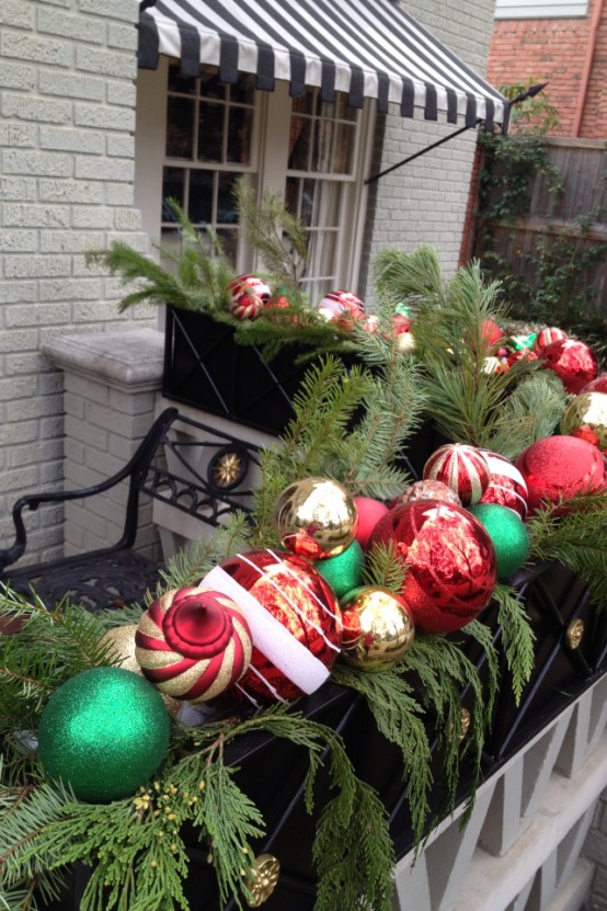 a box with lush evergreens and colorful Christmas ornaments is a great idea for holiday decor