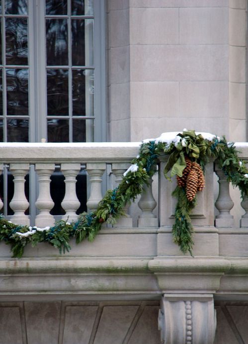 greenery garlands with pinecones will make your balcony look more festive and holiday-ready