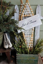 vintage rustic Christmas decor with vintage skis, skates, evergreens and boxwood is lovely and very cozy