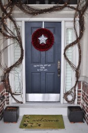 simple Christmas porch decor with vines, lights, a red pinecone wreath with a star is easy to recreate