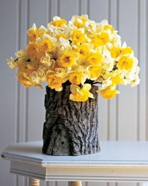 a tree stump with daffodils is a lovely farmhouse or rustic decoration for any space that feels spring