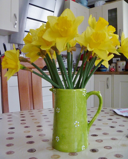 a green jug with daffodils will bring a cool bright touch to your space and a strong spring feel