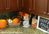 bright orange fall pumpkins and bright fall blooms, a crate with fake pumpkins for fall kitchen decor