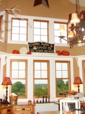 large faux pumpkins and a chalkboard sign for accenting a shelf in the kitchen