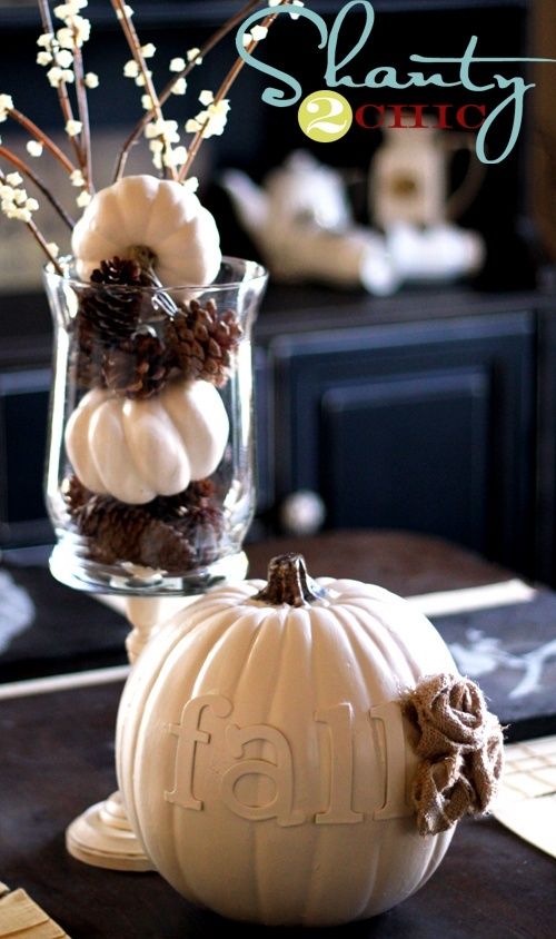 a vase with pinecones and white pumpkins plus some branches with berries and a faux white pumpkin with burlap for party decor