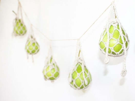 a creative garland of green apples wrpaped with macrame is a cool idea for the fall