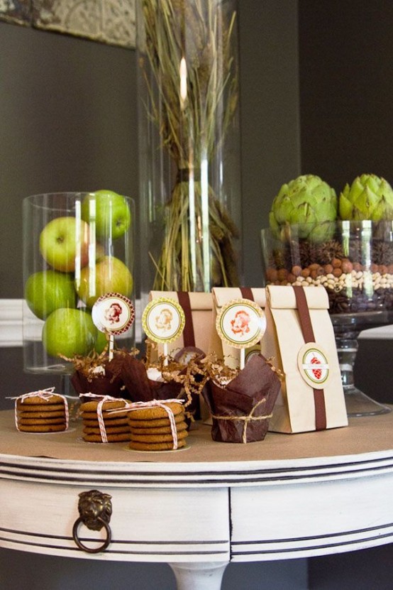 artichokes in a glass bowl with moss and seeds, green apples in a large glass vase for a natural touch