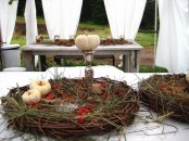 a vine wreath with grass, berries and white pumpkins is a nice fall party centerpiece idea