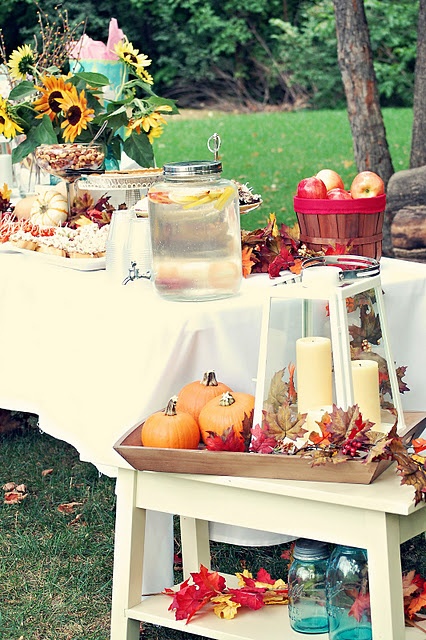 a pretty fall decoration with a wooden tray, pumpkins, fall leaves and a candle lantern is amazing
