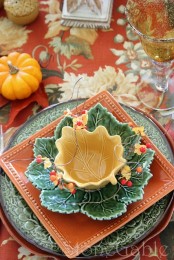 a colorful fall tablescape with whimsy and bright plates including fall leaf ones plus faux pumpkins
