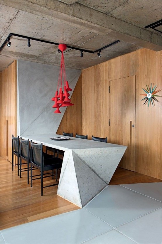 a minimalist meets industrial dining space with a sculptural concrete dining table and red pendant lamps over the table is amazing