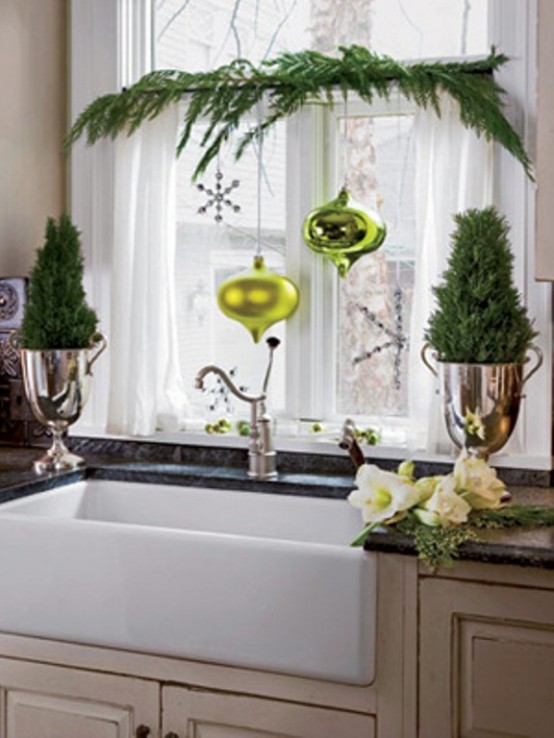 an evergreen window decoration with grene ornaments and a silver snowflake is a lovely piece that can be easily DIYed