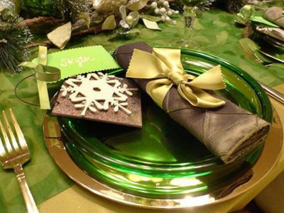 a green, brown and gold Christmas tablescape with evergreens and gold cutlery is a stylish idea for the holidays