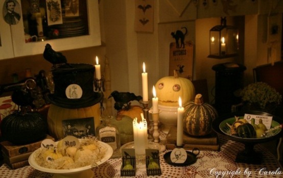 a chic neutral Halloween table setting with scary pumpkins, candles, crows and faux veggies looks mysterious and not too scary