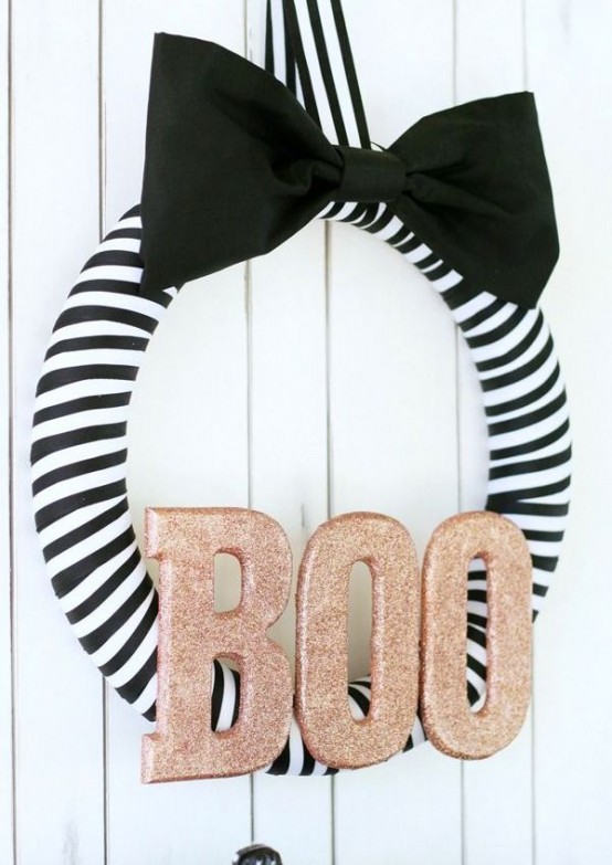 a glam Halloween wreath of a striped form, a large black bow and copper glitter letters is a gorgeous solution