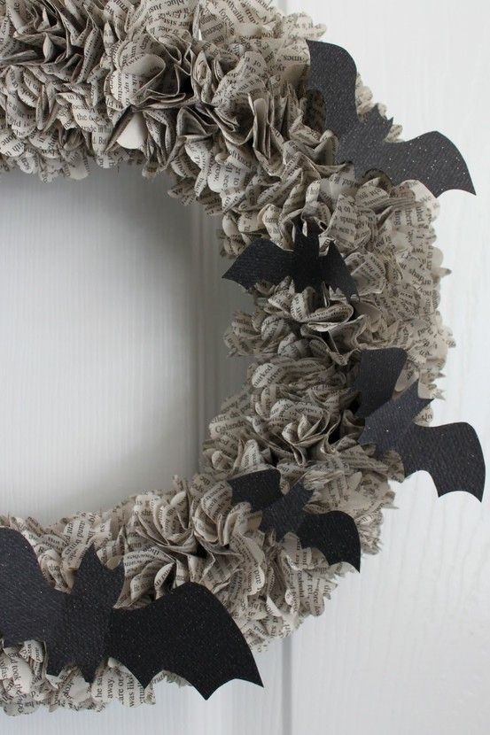 a simple newspaper Halloween wreath accented with black paper bats is a lovely idea to decorate your front door in a sustainable way