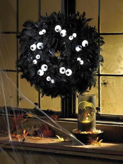 a funny black feather wreath with some eyes is a very catchy and cool idea for Halloween, and the color scheme is a classic one