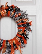 a bold black, orange and white Halloween wreath of fabric stripes only is a great way to upcycle some old fabric you have and get a cool seasonal decoration