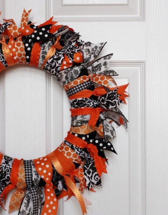 a bold black, orange and white Halloween wreath of fabric stripes only is a great way to upcycle some old fabric you have and get a cool seasonal decoration
