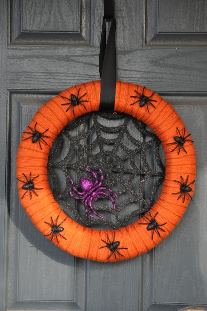 a bold and pretty Halloween wreath of an orange form, a glitter spider net, a purple glitter spider and some black mini spiders on the wreath form